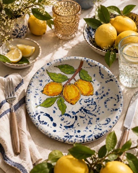 Hand-painted ceramic plate featuring yellow lemons on a leafy branch against a blue and white decorative background, 27cm diameter