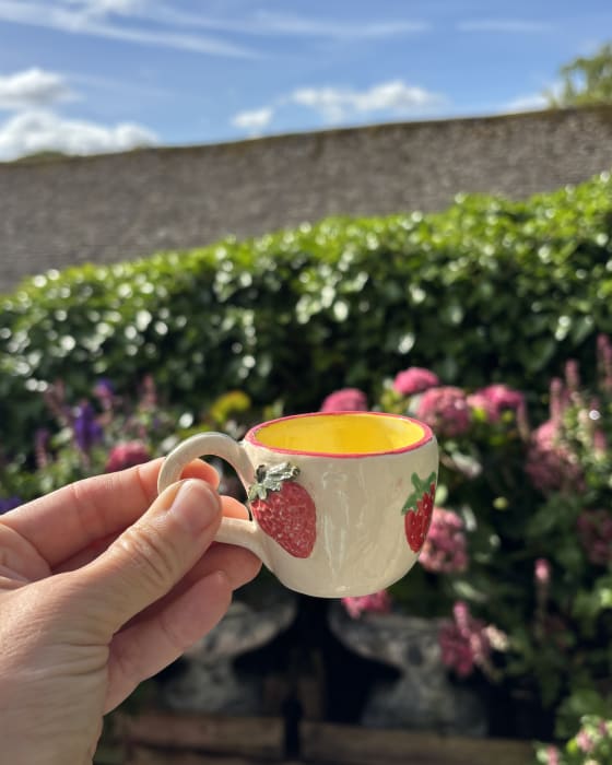 Mini ceramic espresso cup with hand-painted red strawberry pattern and bright yellow glazed interior
