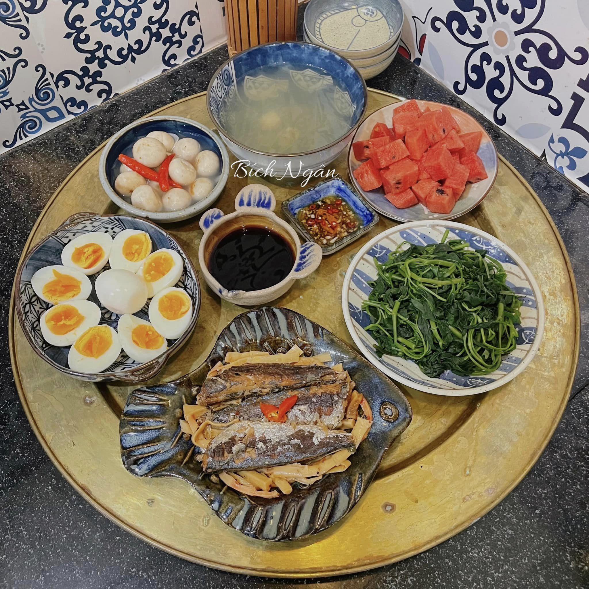 Rau muống luộc, cá nục kho măng, trứng gà luộc, cà pháo, dưa hấu