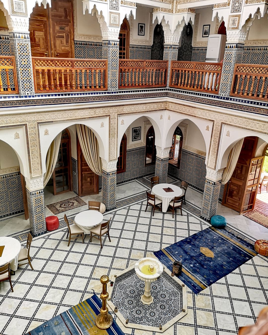 Riad courtyard in Fes with zellige and carved wooden galleries