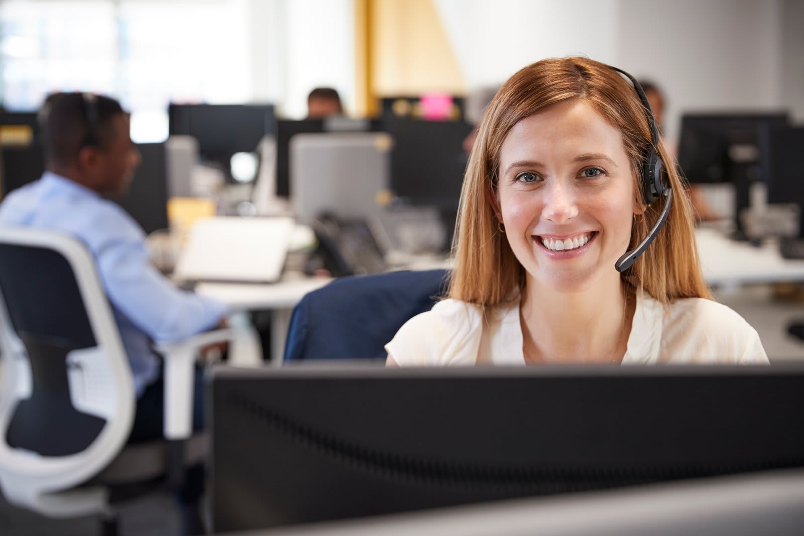 Application support specialist on a headset assisting users from the helpdesk