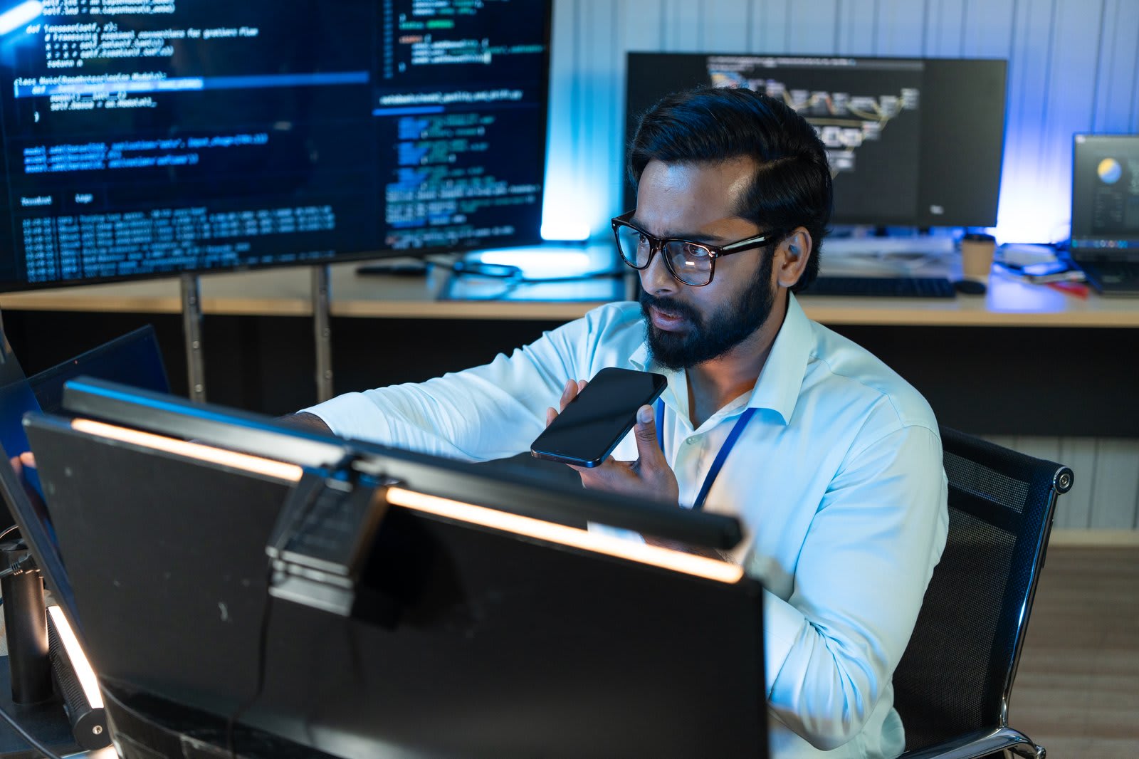 Security engineer reviewing code and network diagrams across multiple monitors