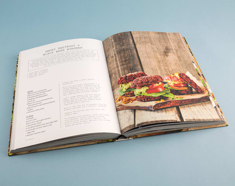 Hardcover cookbook open to plant based burger recipe