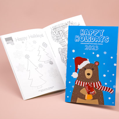 Happy Holidays coloring book with open blank coloring book in background
