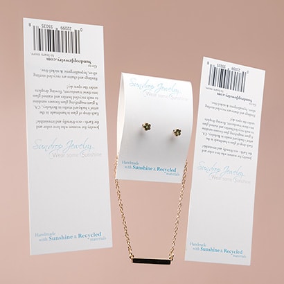 One folded jewelry card with an attached necklace and earringsnext to two unfolded jewelry cards