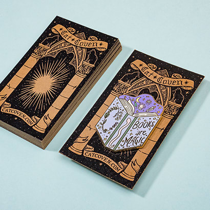 Two intricate pin backing cards, one with a pin attached