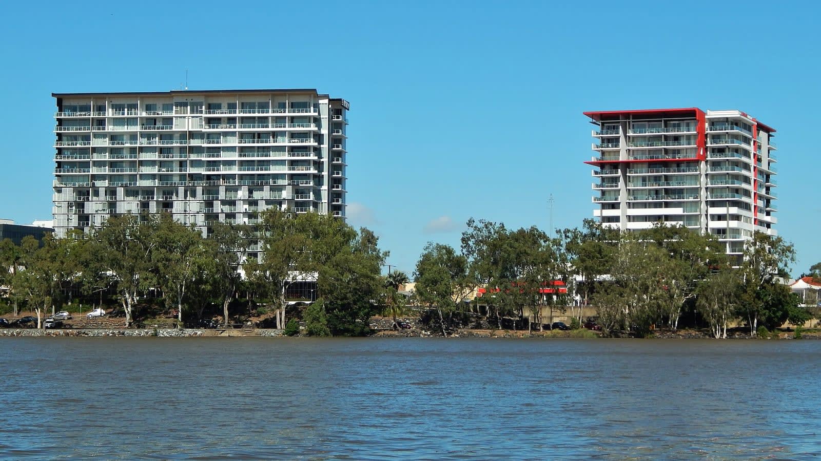 a wide flat river flowing through a forested queensland landscape under a clear sky (file image)