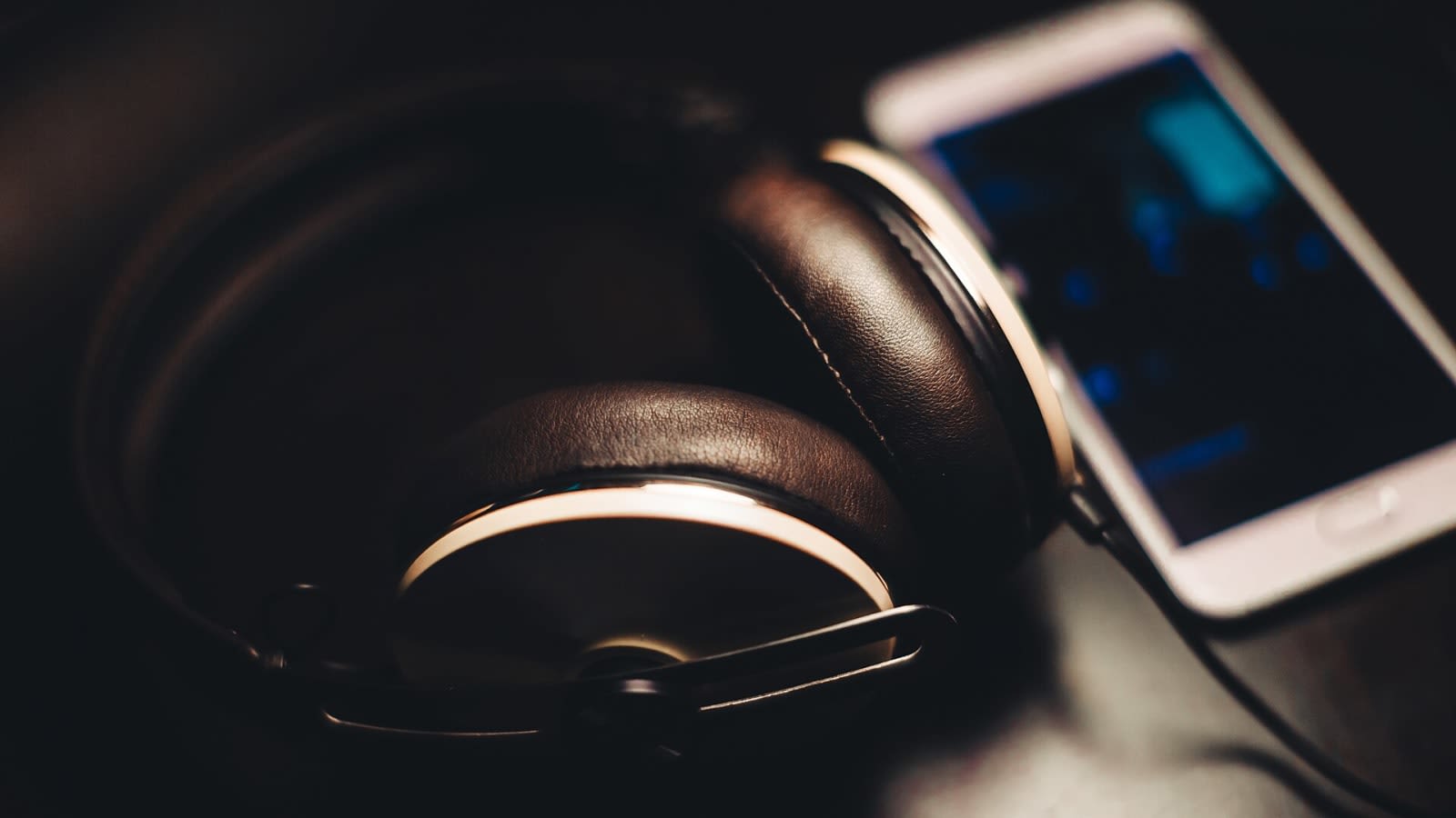 headphones resting beside a smartphone displaying audio waveforms (file image)