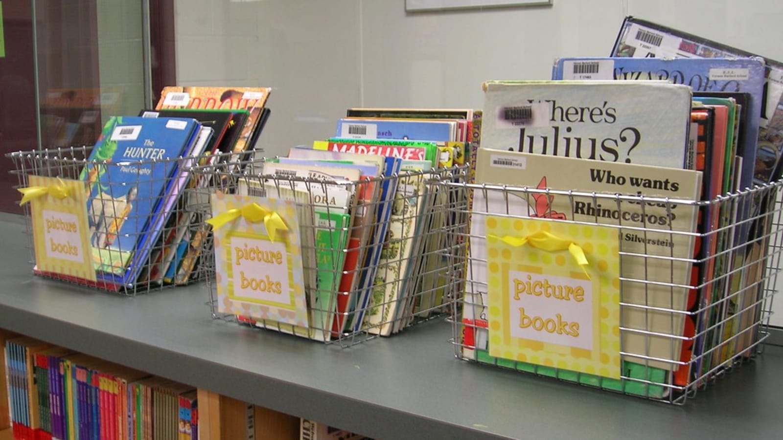 stack of colorful childrens picture books on a wooden library table (file image)