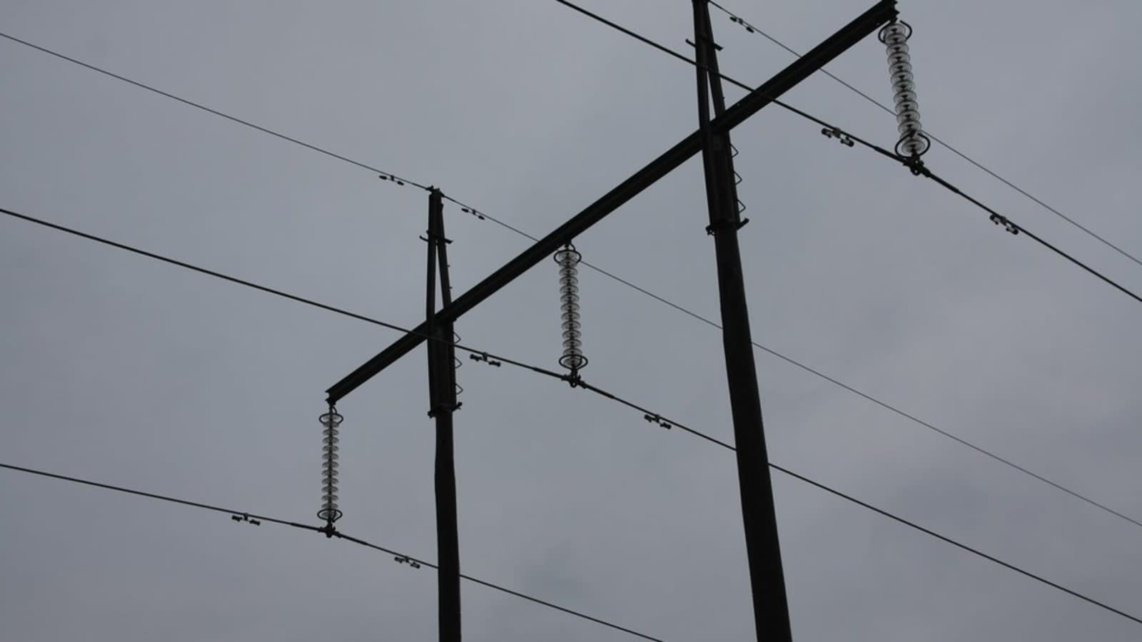 high-voltage power lines running through a snowy mountain landscape (file image)