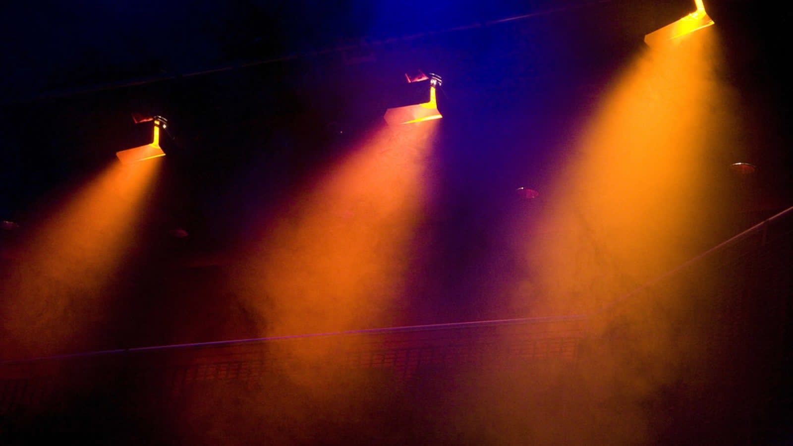 a close-up of a theatrical stage light shining through a dark, empty theatre (file image)