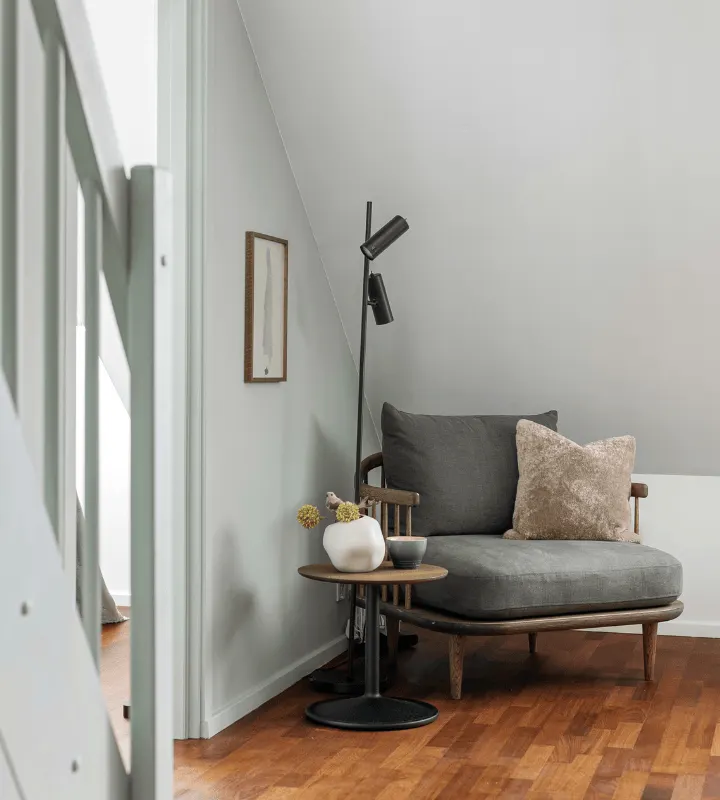 Fauteuil gris devant un escalier