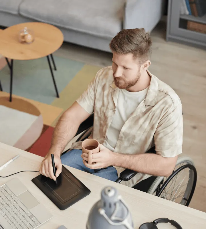 Une femme en fauteuil roulant semble passer un appel sur son ordinateur portable.