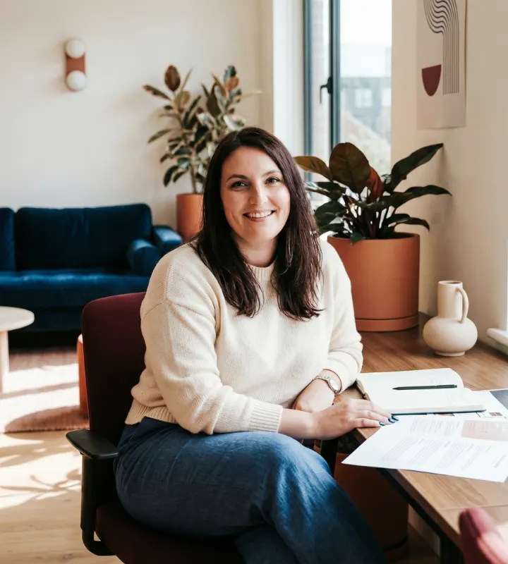 Une femme assise sur une chaise près de son bureau