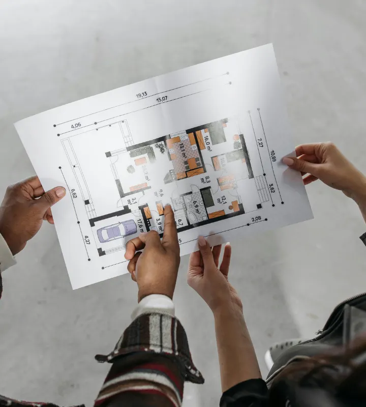 Deux personnes étudient un plan immobilier.