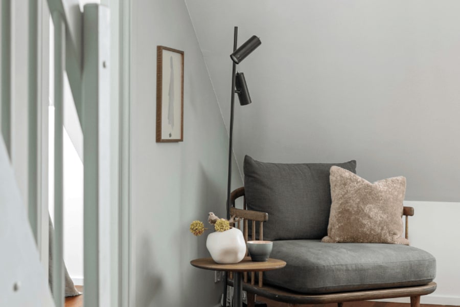 Fauteuil gris devant un escalier