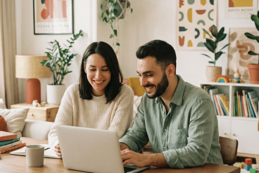 Couple devant un ordinateur en recherche immobilière