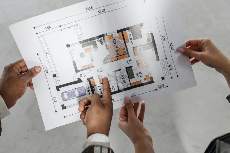 Deux personnes étudient un plan immobilier.