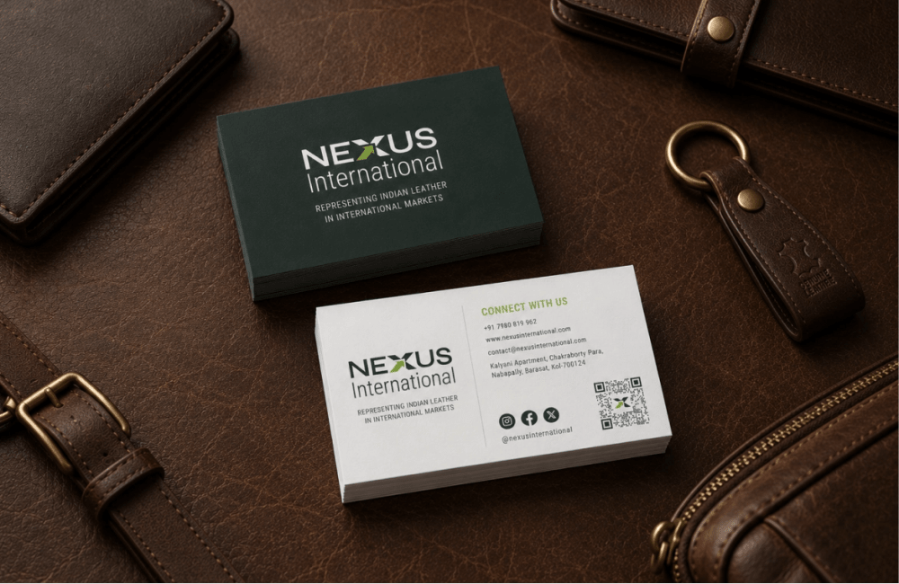 Nexus International business cards on a leather surface