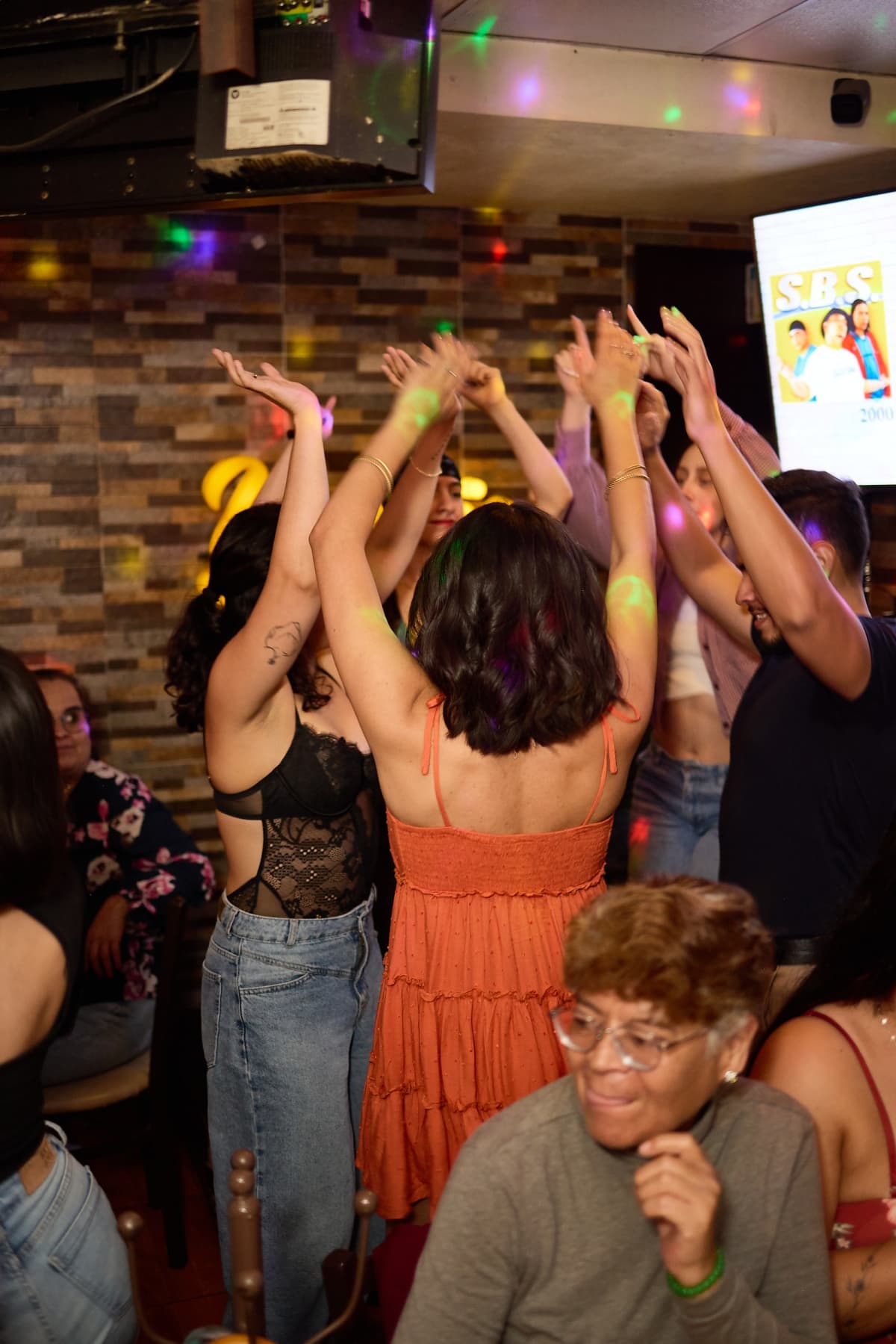 Amigas bailan y cantan en Yardis, con luces de fiesta