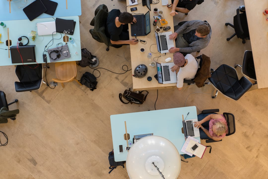 overhead of workers in an offices using laptops