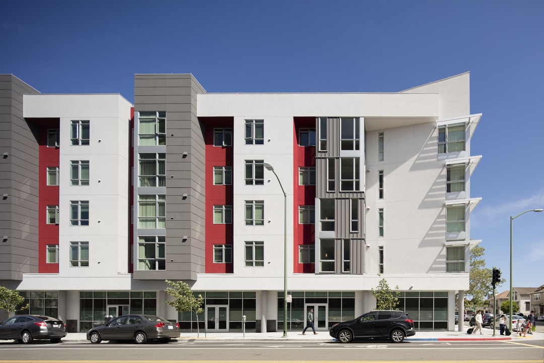 Photograph of an apartment complex with red accents.