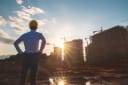 Architect gazing at construction site at sunset