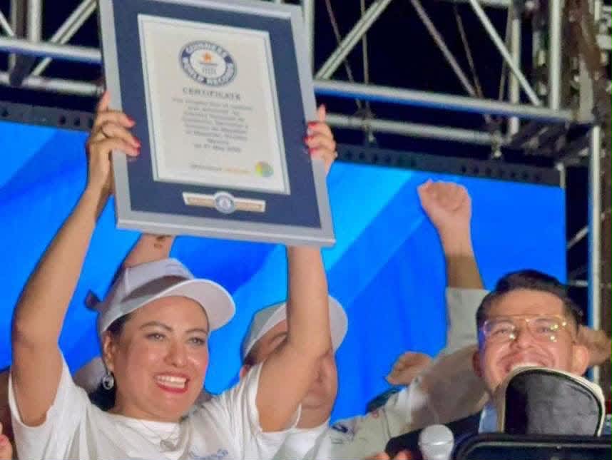 Celebración en el escenario con el certificado de Guinness World Records en alto