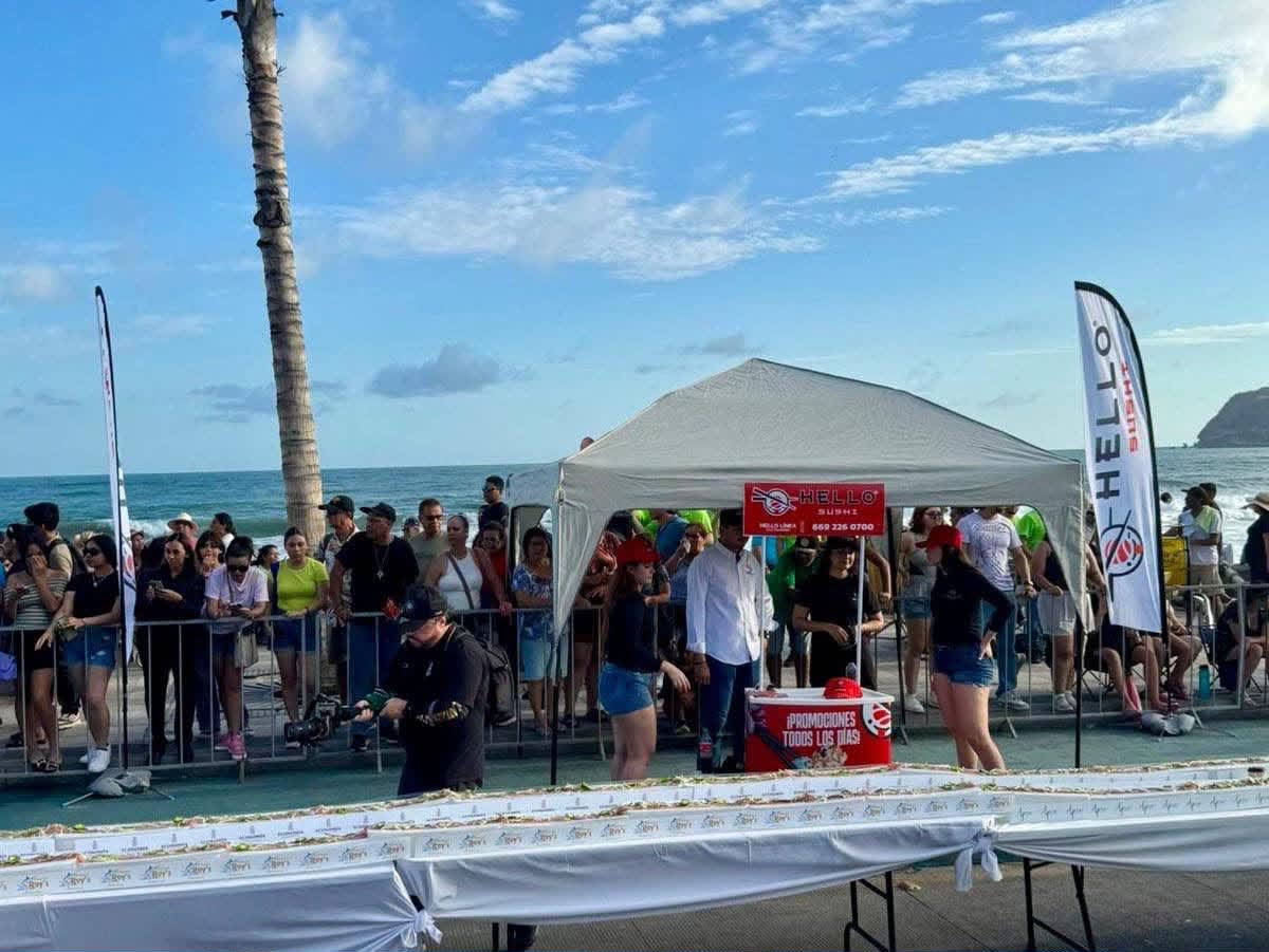 Vista del puesto de Hello Sushi frente al mar y de las mesas con la línea de sashimi