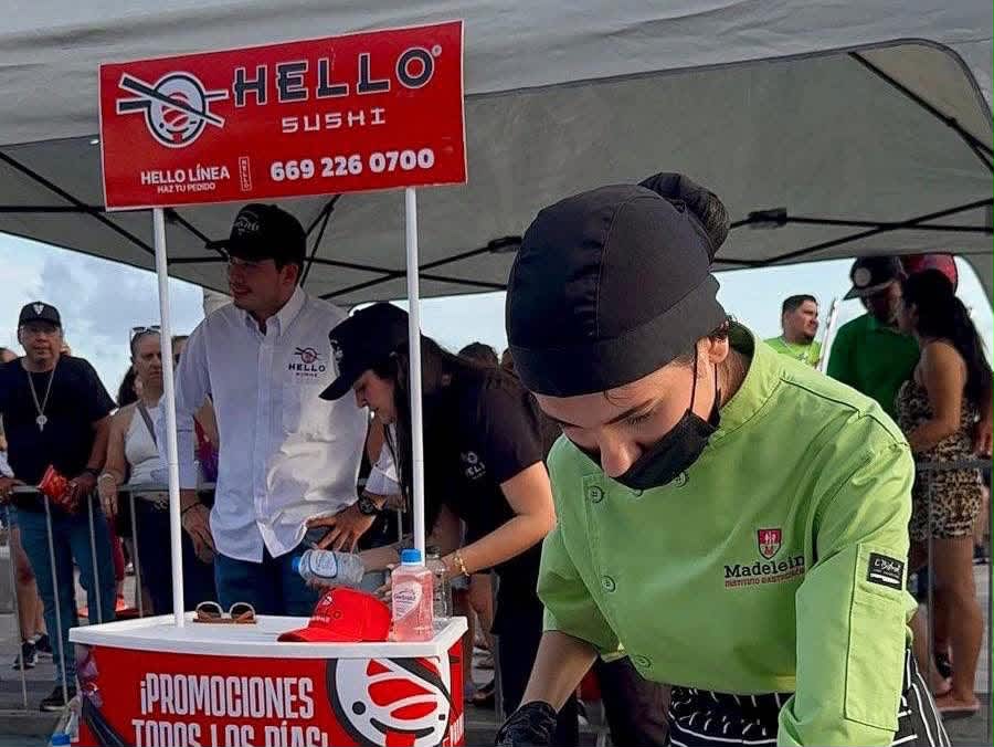 Participante del Instituto Madeleine prepara sashimi junto al puesto de Hello Sushi