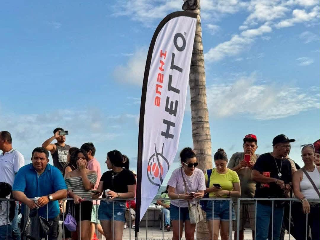 Público reunido en el Malecón junto a una bandera de Hello Sushi