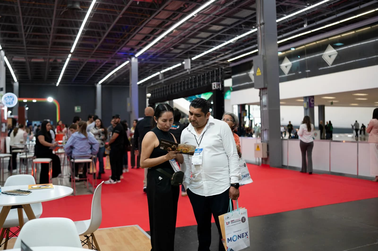 Integrante del equipo de Hello Sushi conversa con una visitante en el stand