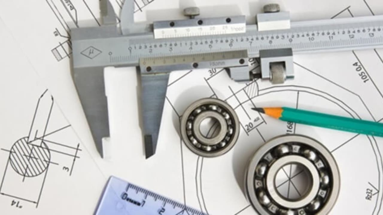 Mechanical workshop measuring instruments laid out — Vernier caliper, micrometer, steel rule, and gauges