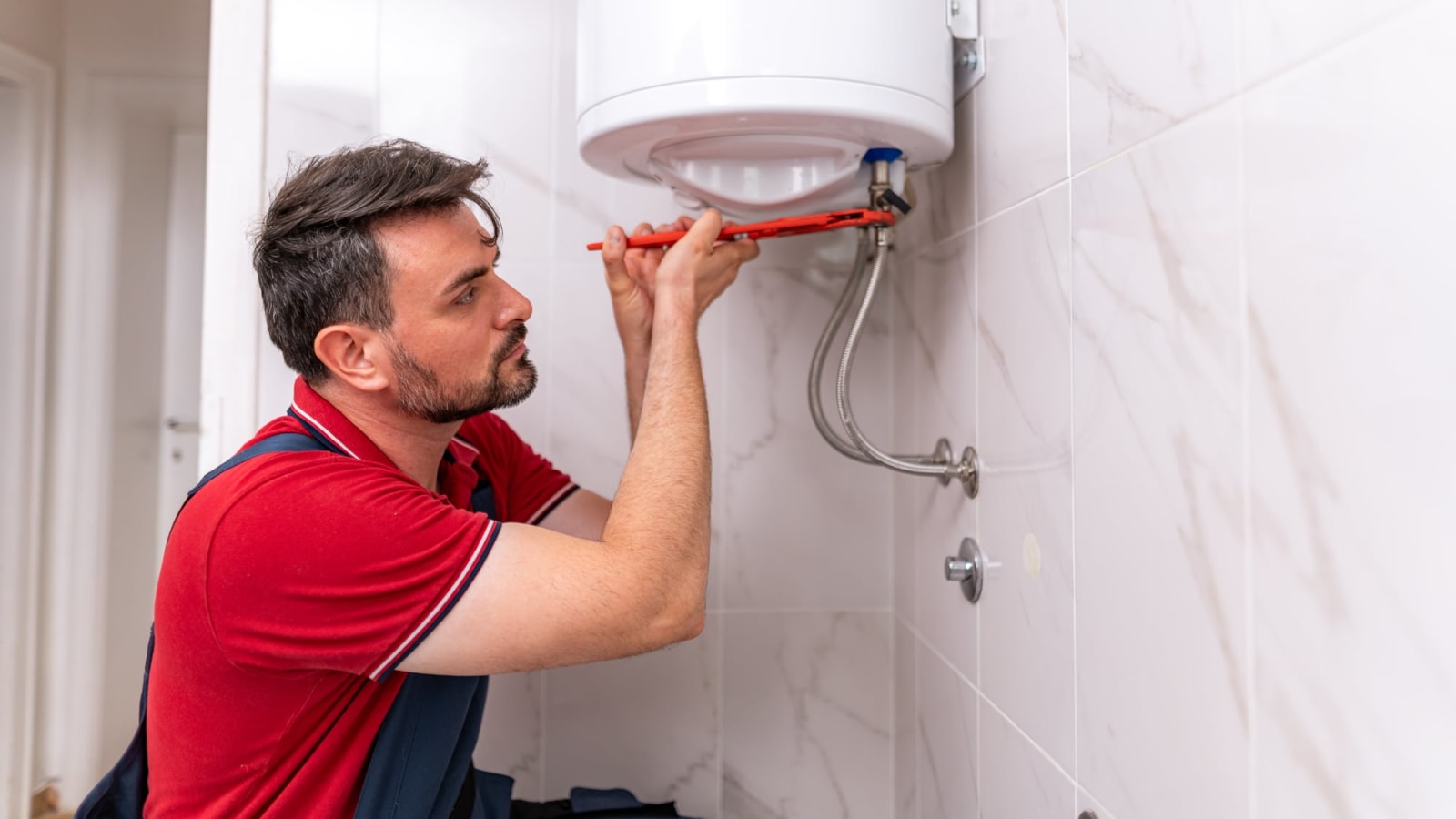 Plombier partenaire diagnostiquant une panne sur un chauffe-eau électrique
