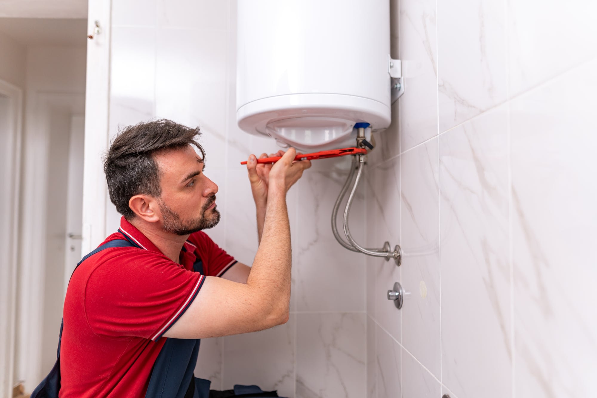 Plombier intervenant sur un chauffe-eau électrique