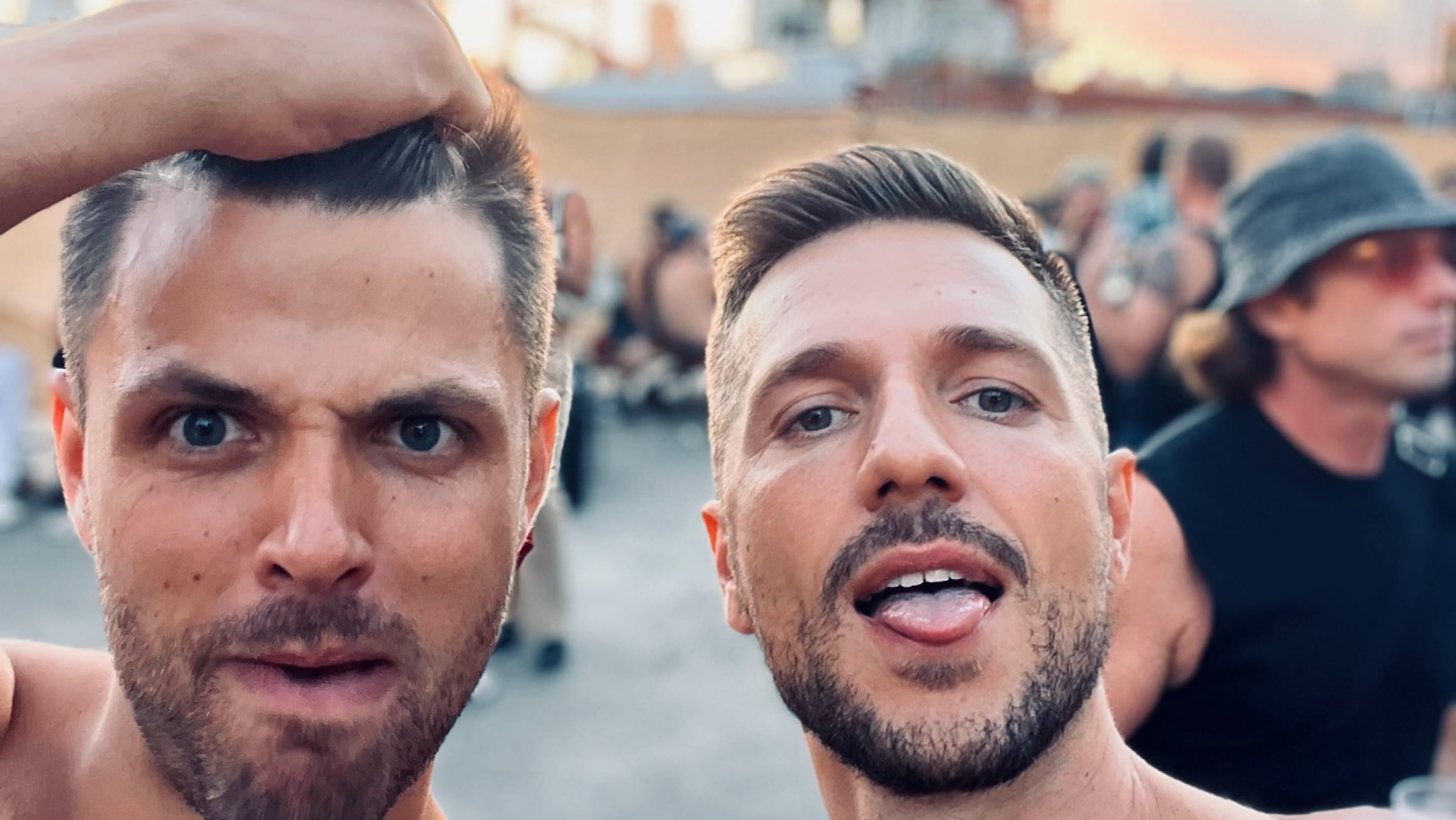 Two joyful men taking a selfie with the sun setting at Adonis, one of the best gay clubs in London.