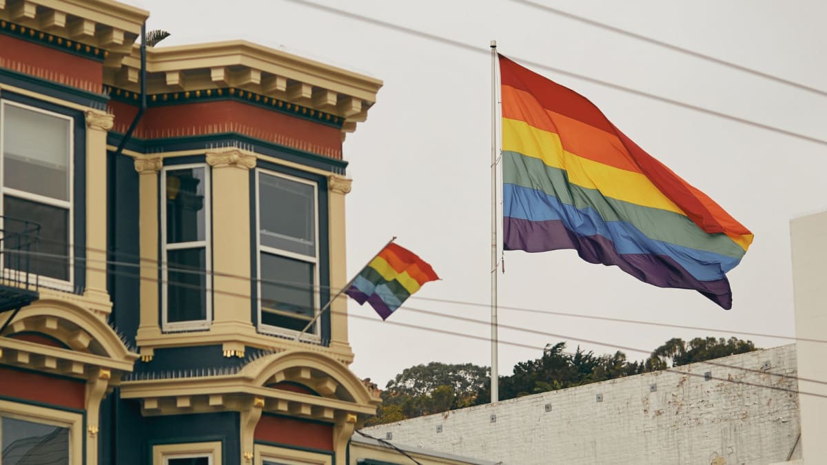 The iconic rainbow flag flies high against the backdrop of Victorian architecture, marking the celebration of gay pride in San Francisco, a beacon of LGBTQ+ culture in the USA.