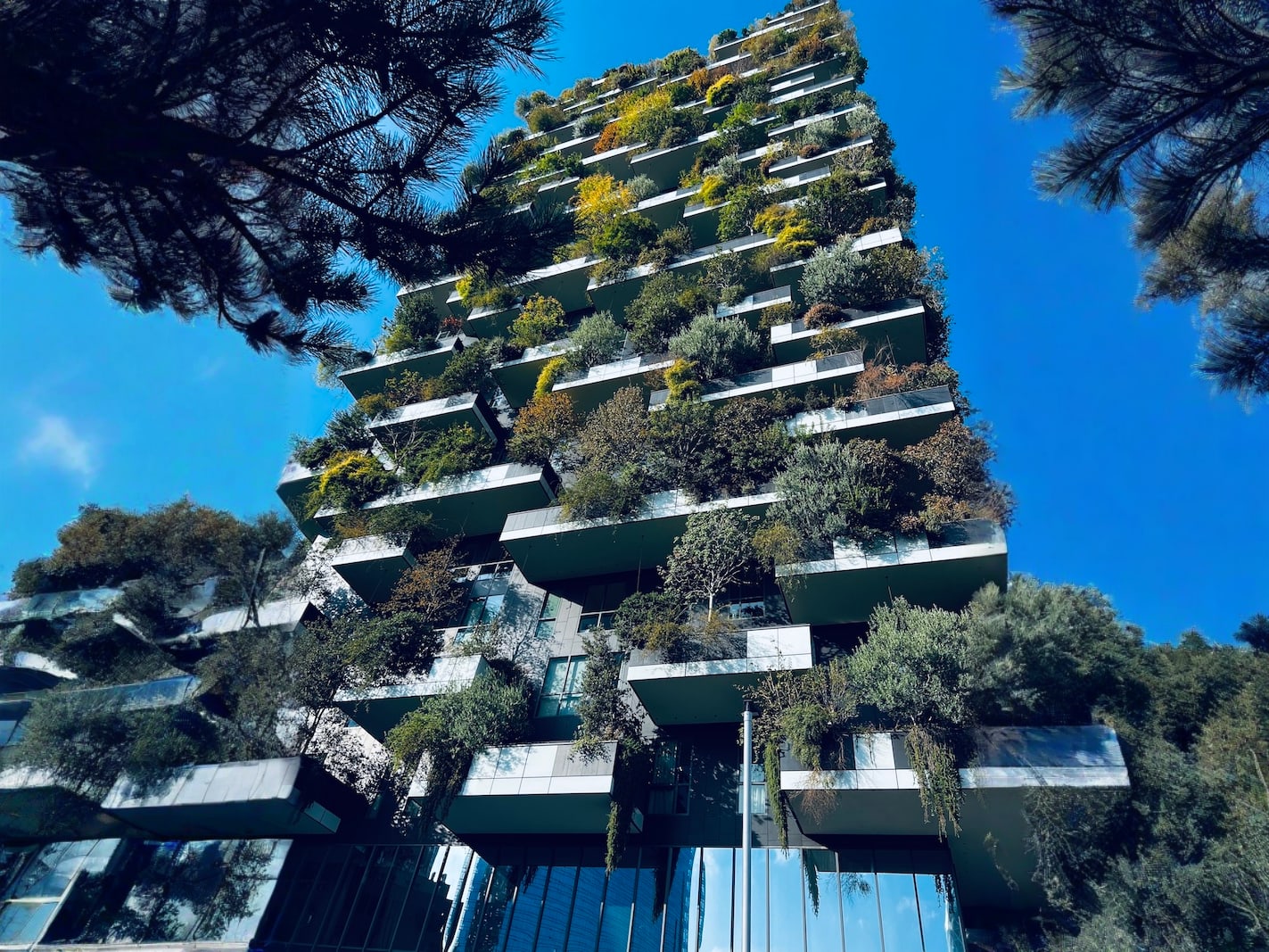 Modern residential building in Milan called Bosco Verticale, adorned with vertical gardens on each balcony, showcasing urban green architecture.