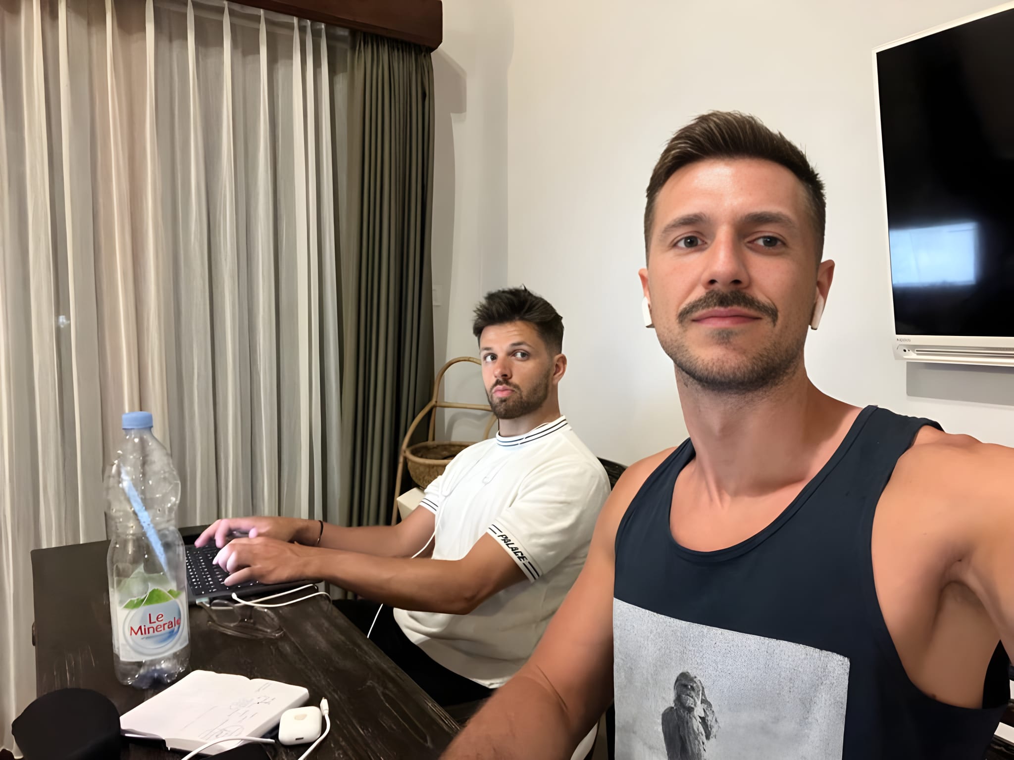 Two digital nomads working remotely from a minimalist styled home office in Bali, reflecting the modern work culture among expatriates in Indonesia.