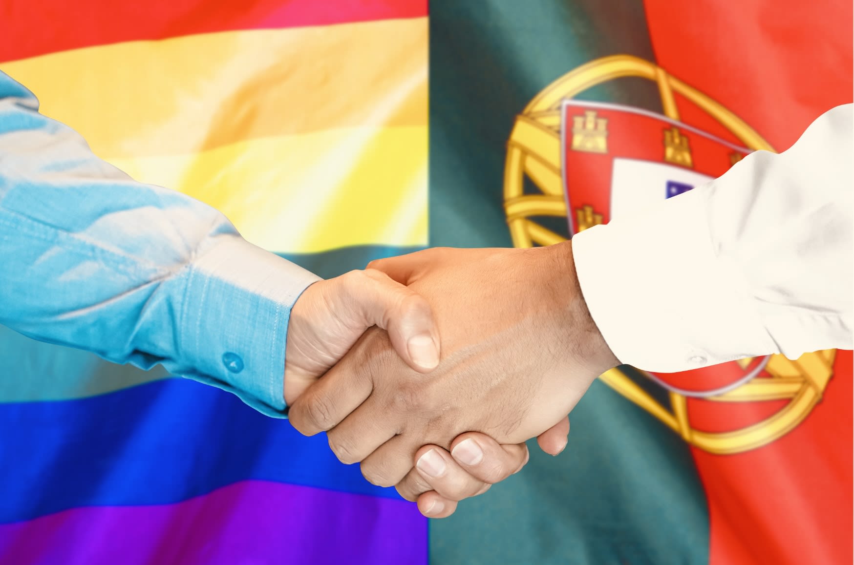 Two hands shaking in front of the rainbow flag and the Portuguese flag, symbolizing the welcoming spirit of gay Lisbon.