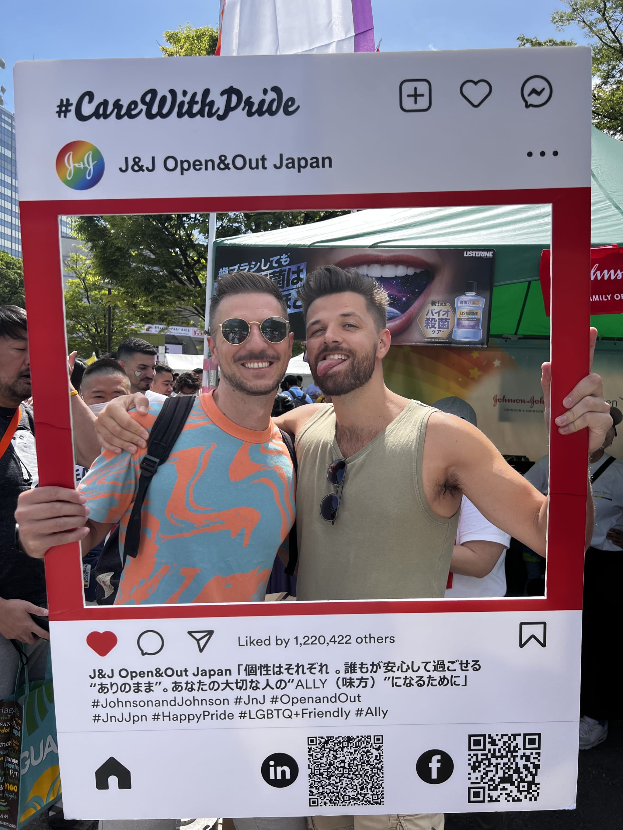 Two people are smiling and posing together in a large Instagram-style photo frame at an outdoor event, celebrating Asian gay pride in Tokyo. The frame features hashtags related to #Pride2025, #AsianGayPride, and #Allyship. They're under a clear sky with trees and tents in the background, marking an important date on the 2025 calendar.