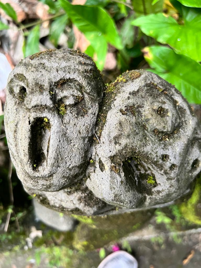 Close-up of a unique stone sculpture covered in moss in Bali, exemplifying the island's rich cultural heritage that attracts those interested in Indonesia's artistic environment. A perfect place for Ubud travel.