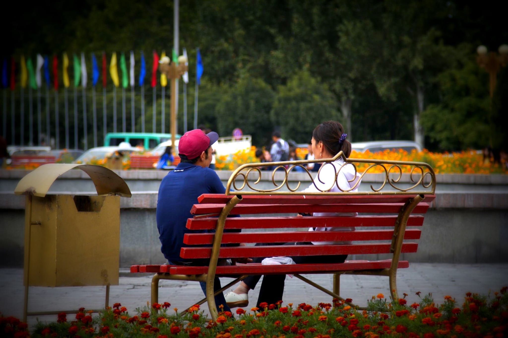 Locals enjoying a sunny day on a bench in Ala-Too Square, Bishkek, a popular spot for relaxation and people watching.
