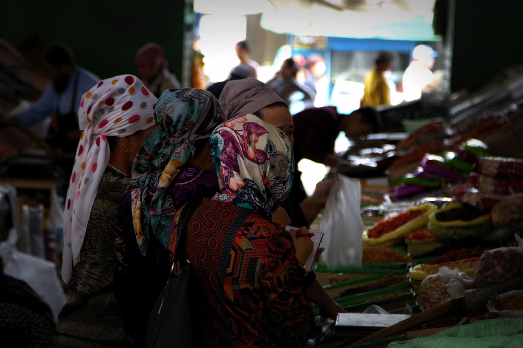 Local women shopping at Osh Bazaar in Bishkek, Kyrgyzstan, a lively market scene showcasing the cultural diversity and local lifestyle.