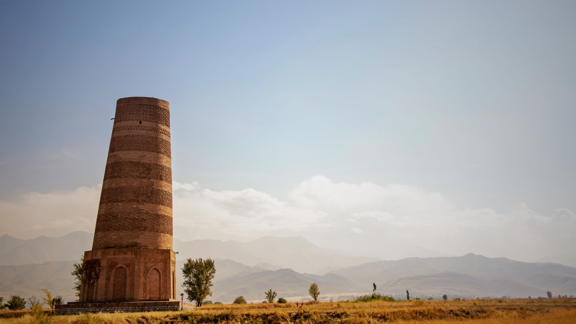 Burana Tower, a historic minaret near Bishkek, Kyrgyzstan, surrounded by mountains and blue sky, a must-visit for history enthusiasts exploring things to do in Bishkek.