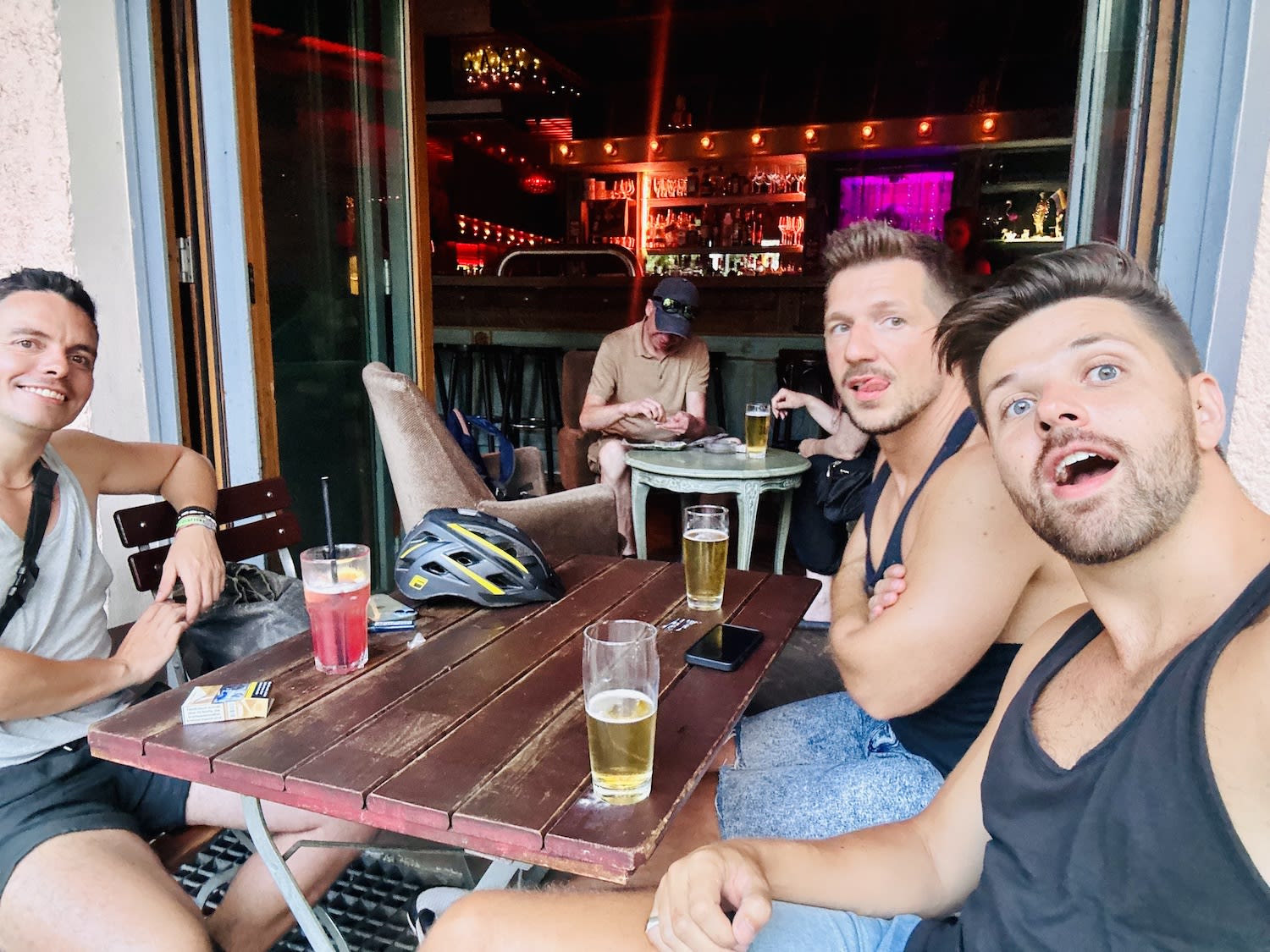 three men drinking beer outside at Capture Bar in Berlin