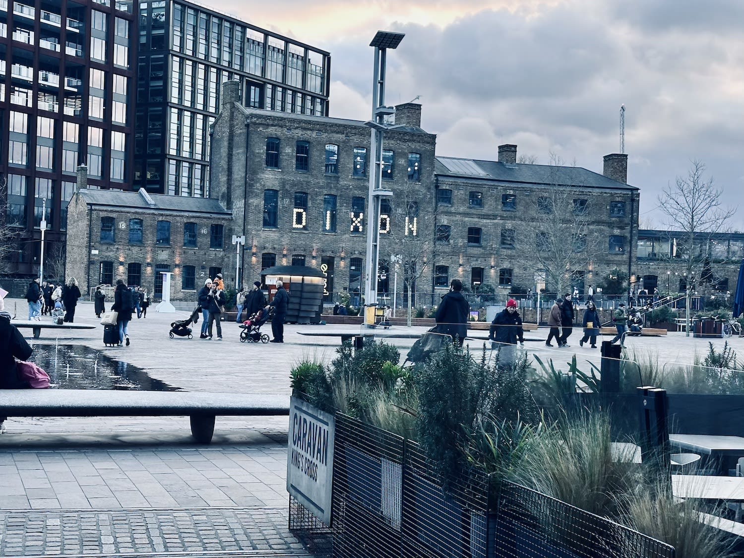 A dusk view of Coal Drops Yard in London, where historic architecture meets contemporary public spaces, a blend of the past and present in Gay London.