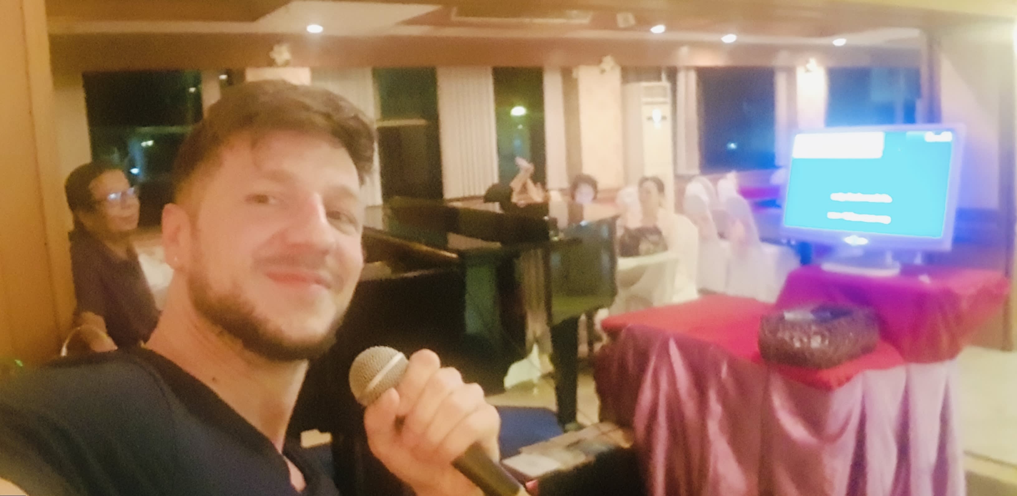 Tourist singing karaoke at a Bangkok bar, a fun night activity for a 14 day Thailand itinerary.