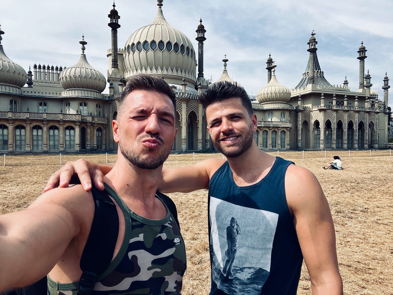 Two men taking a selfie in front of the Royal Pavilion in Brighton, showcasing the elaborate Indian style architecture, perfect for exploring gay Brighton's historical sites.