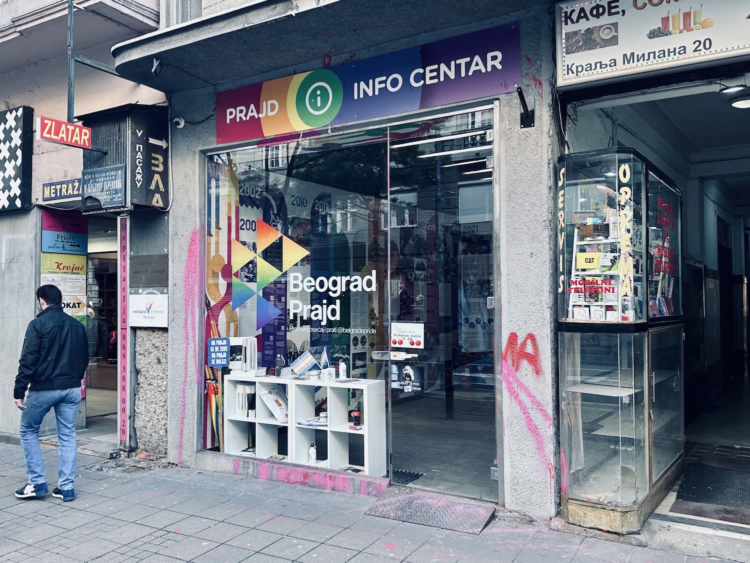 The exterior of the Belgrade Pride Information Center, located on a busy street in the city. The shop’s colorful signage promotes LGBTQ+ awareness and support in Serbia, a country with a growing but still challenging environment for LGBTQ+ rights. Keywords: facts about Serbia.